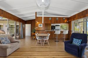 a living room with a couch and a table at Hannah's Bay Lakefront in Rotorua
