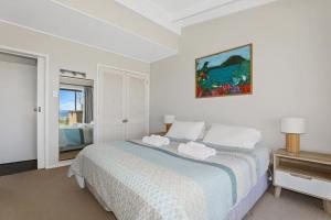 a bedroom with a bed with towels on it at Hannah's Bay Lakefront in Rotorua