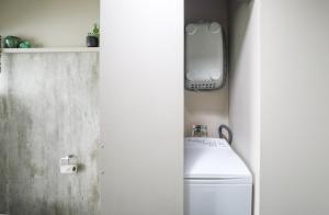 a bathroom with a toilet and an iphone on a shelf at Hannah's Bay Lakefront in Rotorua