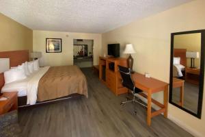チーフランドにあるQuality Inn near Manatee Springs State Parkのベッド1台、デスク、ベッドルーム1室が備わります。