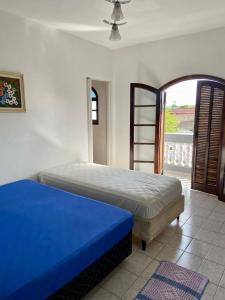 伊瓜佩的住宿－Casa Canto do Morro - Iguape，一间卧室配有一张蓝色床垫和窗户。