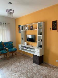 伊瓜佩的住宿－Casa Canto do Morro - Iguape，客厅设有娱乐中心和电视