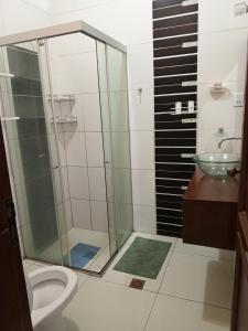 a bathroom with a shower and a toilet and a sink at Guajira Hostel SCZ in Santa Cruz de la Sierra