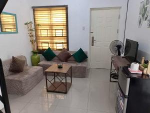 a living room with a couch and a tv at Honeydew Transient House in Mabiga
