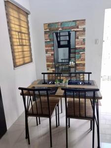 a dining room with a table and chairs and a mirror at Honeydew Transient House in Mabiga