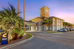 um grande edifício com uma torre de relógio num parque de estacionamento em Comfort Inn & Suites Airport Convention Center em Charleston