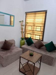 a living room with two couches and a table at Honeydew Transient House in Mabiga