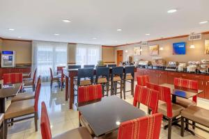a restaurant with tables and chairs and a bar at Comfort Inn & Suites Airport Convention Center in Charleston