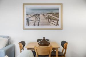 a dining room with a table and a picture on the wall at Beach Views at Oceanside in Mount Maunganui +11 photos