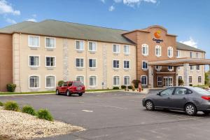 un gran edificio con coches estacionados en un estacionamiento en Comfort Inn DeKalb - Adjacent the University, en DeKalb