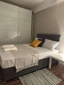 a bedroom with a large bed with a yellow pillow at 3 Bedroom Entire Flat, Primrose Hill in London
