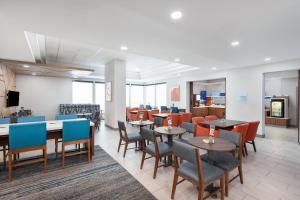 a dining room with tables and chairs and a cafeteria at Holiday Inn Express Atlanta West - Theme Park Area, an IHG Hotel in Lithia Springs