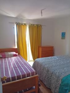 1 dormitorio con 2 camas y ventana en Don Fernando en El Quisco