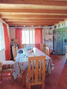 uma sala de jantar com uma mesa e cadeiras num quarto em Don Fernando em El Quisco