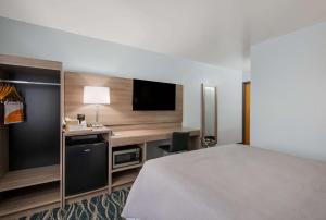 a hotel room with a bed and a flat screen tv at Quality Inn in Oneida