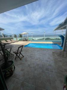 a swimming pool with a view of the ocean at Hotel Aconchego Da Vila in Saquarema