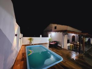 a swimming pool in a room with a house at Casa piscina 8 pessoas in Saquarema