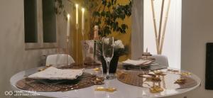 uma mesa de jantar com uma tampa de mesa branca com decorações douradas em Loft Spa La Maison du Bambou em Sequedin