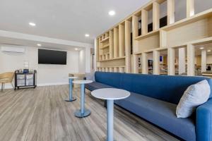 a living room with a blue couch and two tables at Comfort Inn Sea World Area in San Diego