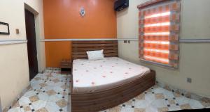 a bedroom with a bed in a room with a window at Prime PH Home in Port Harcourt