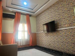 a living room with a tv on a wall at Prime PH Home in Port Harcourt