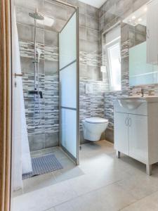 La salle de bains est pourvue d'une douche, de toilettes et d'un lavabo. dans l'établissement Apartments with a parking space Kastel Stari, Kastela - 22588, à Kaštela