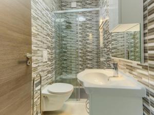 La salle de bains est pourvue de toilettes blanches et d'un lavabo. dans l'établissement Apartments with a parking space Kastel Stari, Kastela - 22588, à Kaštela