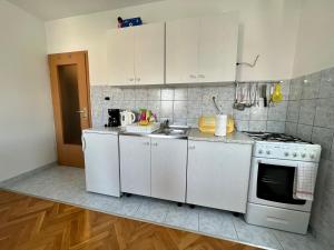 a kitchen with white cabinets and a sink and a stove at Apartments with a parking space Kastel Luksic, Kastela - 22593 in Kaštela
