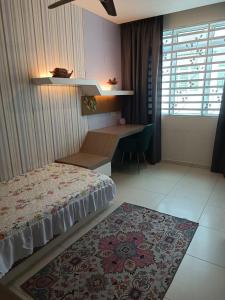 a bedroom with a bed and a desk and a rug at AYRA HOMESTAY in Kuala Kangsar