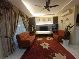 sala de estar con 2 sofás y TV de pantalla plana en AYRA HOMESTAY, en Kuala Kangsar