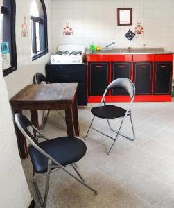 チョアチにあるAparta Hotel Bella Vistaのキッチン(椅子2脚、木製テーブル付)