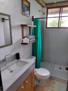 a bathroom with a sink and a toilet and a shower at Casa Ariana, Acepto Mascota in Ayampe