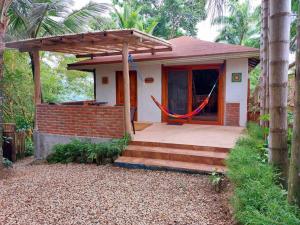 a small house with a porch with a hammock at Casa Ariana, Acepto Mascota in Ayampe