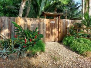 a wooden fence with a gate in a garden at Casa Ariana, Acepto Mascota in Ayampe