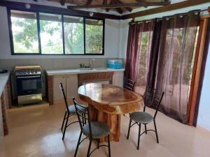 a kitchen with a wooden table and four chairs at Casa Ariana, Acepto Mascota in Ayampe