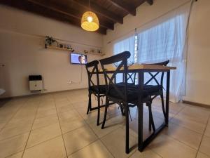 a table and chairs in a room with a tv at Moderno departamento en Godoy Cruz in Godoy Cruz