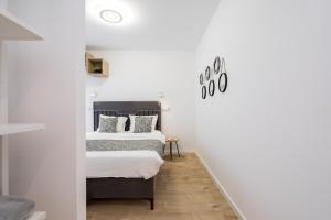 two beds in a room with white walls and wood floors at Breeze - Lovely Apartment in Aviatiei with Parking in Bucharest