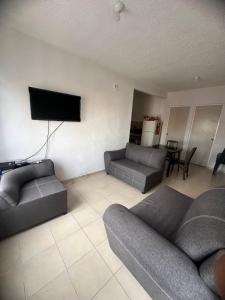 sala de estar con 2 sofás y TV de pantalla plana en Departamento playa del carmen, en Playa del Carmen