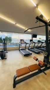a gym with several tread machines in a room with a view at Encantador Apto na Beira do Lago! in Brasilia