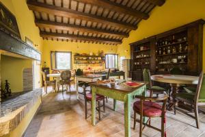 a dining room with tables and chairs and a fireplace at Agriturismo Corte Decia in Saludecio