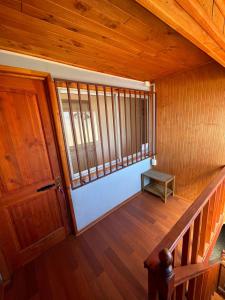 an empty room with a wooden door and a stair case at Casa Amoblada en Coronel 2 in Coronel
