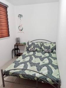 a bedroom with a bed with a camouflage bedspread at Honeydew Transient House in Mabiga