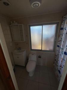 a small bathroom with a toilet and a window at Casa Amoblada en Coronel 2 in Coronel