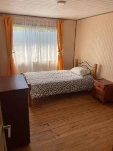 a small bedroom with a bed and a window at Casa Amoblada en Coronel 2 in Coronel