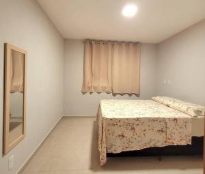 a bedroom with a bed and a mirror in it at Apê em condomínio, com Piscina, na melhor localização de Ilhéus in Ilhéus