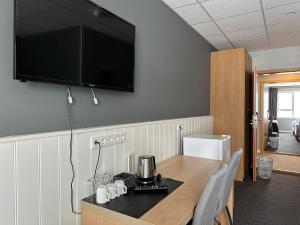 a kitchen with a table with a television on the wall at Hotel Kanslarinn Hella in Hella