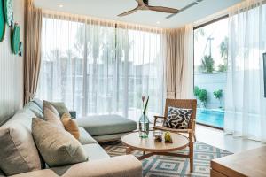 ein Wohnzimmer mit einem Sofa und einem Tisch in der Unterkunft The Ocean Resort Quy Nhon by fusion in Quy Nhon
