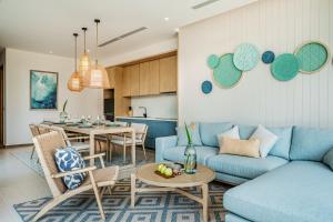 uma sala de estar com um sofá e uma mesa em The Ocean Resort Quy Nhon by fusion em Quy Nhon