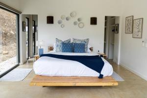 een slaapkamer met een groot bed met blauwe kussens bij Three Rabbits Run in Myrtleford