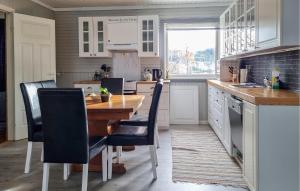 uma cozinha com uma mesa de madeira e cadeiras pretas em Awesome Apartment In ysleb With House Sea View em Marnardal